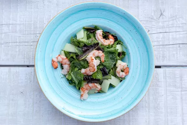 Draufsicht eines Garnelensalats mit Melone, Prosciutto-Schinken und Zitrone-Kaviar Creme