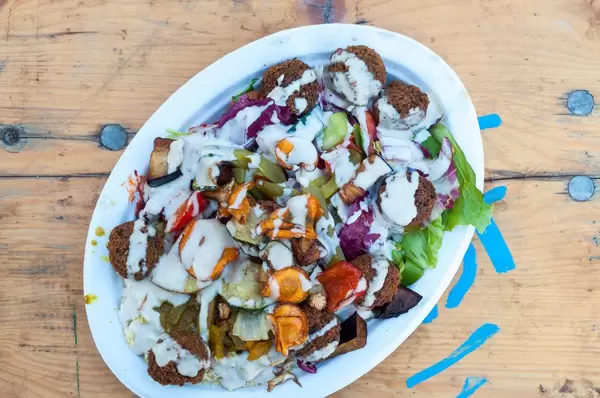 Draufsicht eines Hummus-Tellers mit Falafel und Magali