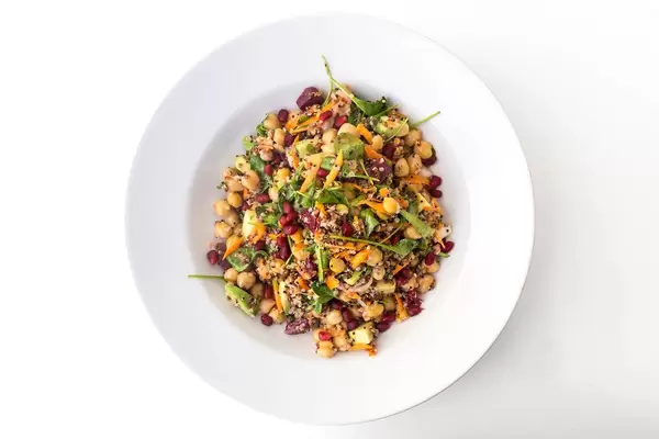 Draufsicht: veganes Gericht mit Kichererbsen, roter Bete, Möhren, Avocado, Quinoa, Spinat und Kräutern