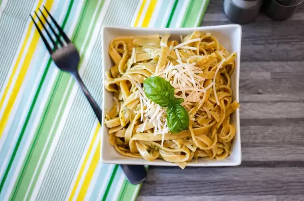 Draufsicht von Bandnudeln mit Pesto und geriebenem Käse