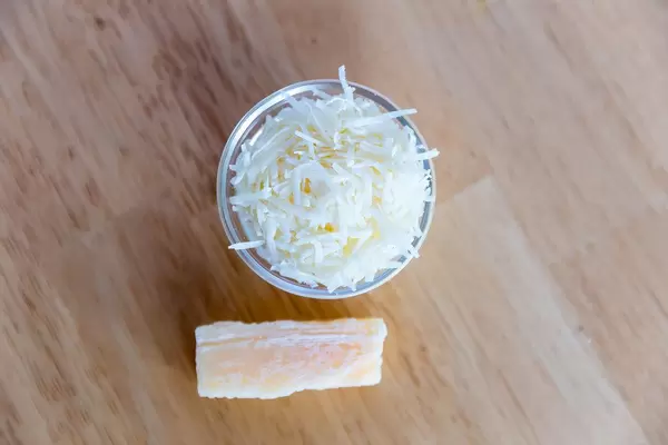 Draufsicht von geriebenem Käse in kleiner Glasschüssel