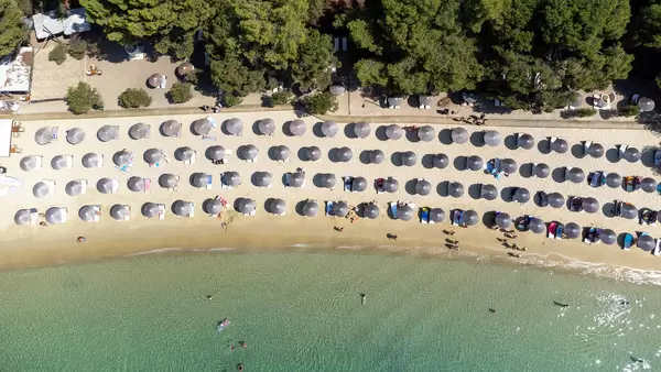Draufsicht von Sonnenschirmen auf den traumhaften Strand von Koukounaries in Griechenland