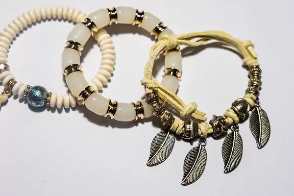 Drei Armbänder für Damen im Stil von indianischem Schmuck vor weißem Hintergrund