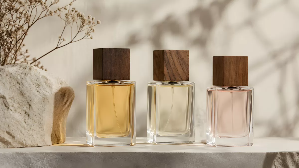 Drei elegante Parfumflakons mit Holzdeckeln auf Ablage