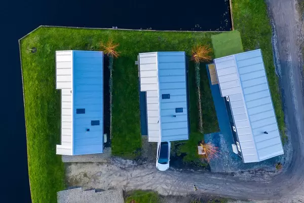 Drei Häuser am Wasser aus der Luft fotografiert in Akmarijp, Niederlande