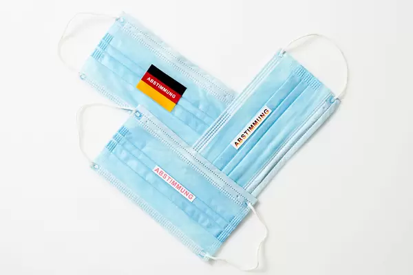 Drei medizinische Masken und die Schrift "Abstimmung" für die Bundestagswahl 2021