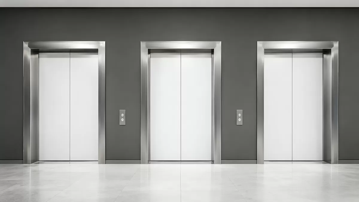 Drei moderne Aufzüge mit weißen Türen im Bürogebäude