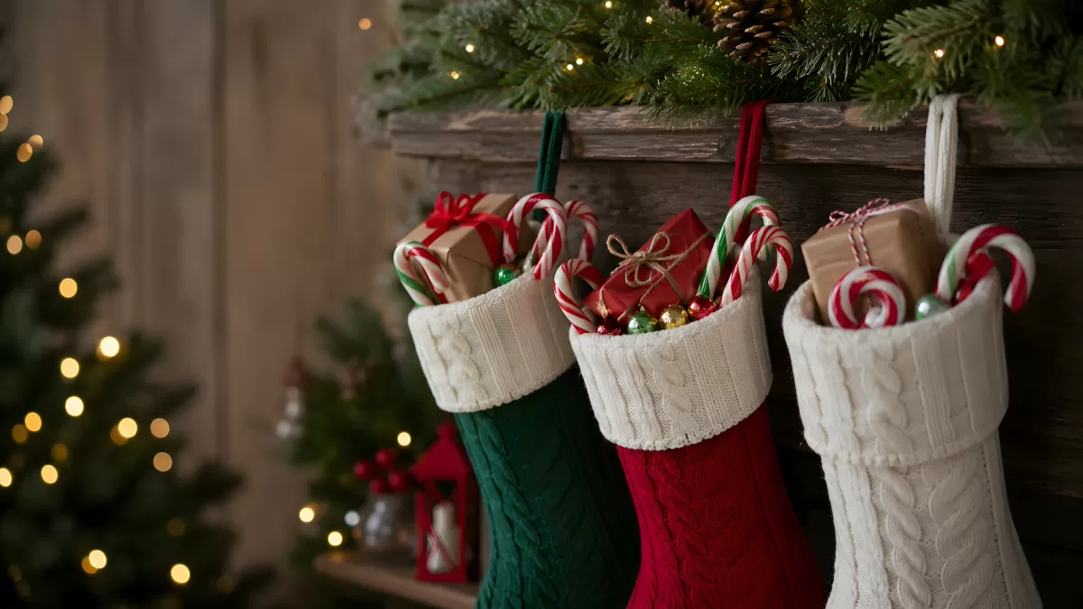 Drei Weihnachtsstrümpfe am Kamin mit Süßigkeiten