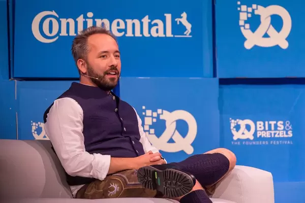 Drew Houston von Dropbox in Lederhosen auf der Couch von Gründermesse Bits & Pretzels