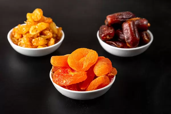 Dried apricots, raisins and dates in white masks on a black background (Flip 2020)