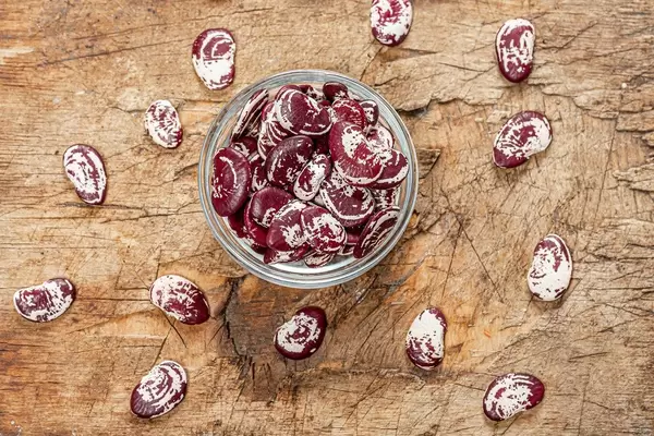 Dried beans in a glass bowl on an old wooden background. Top view (Flip 2019)