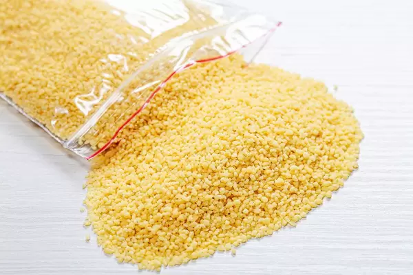 Dried couscous seeds on white wooden background (Flip 2019)