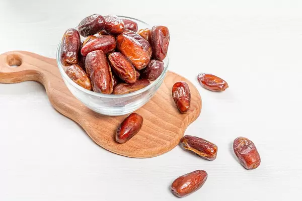 Dried dates in a glass bowl on the kitchen Board