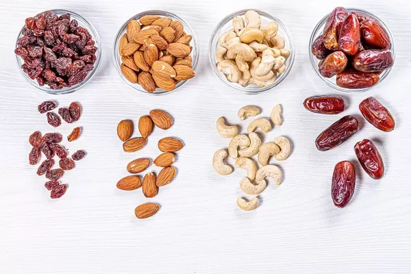 Dried dates, raisins, cashew nuts and almonds on white wooden background (Flip 2019)