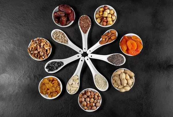 Dried-fruits-nuts-and-seeds-in-spoons-and-bowls-on-a-black-background-top-view.jpg