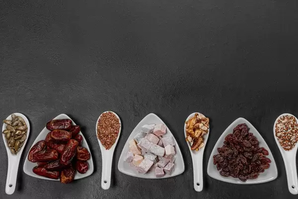 Dried fruits, nuts and seeds on a black background with free space. Healthy food concept (Flip 2019)