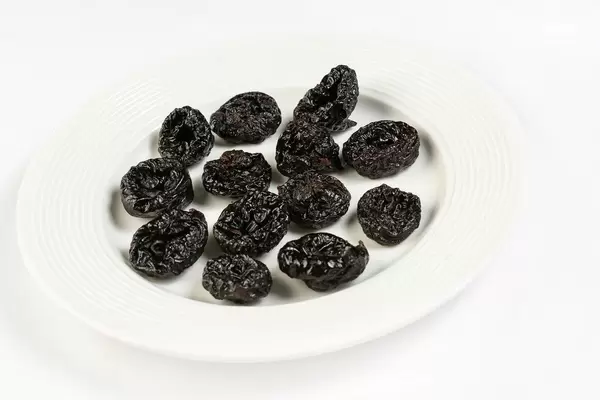 Dried Plums above white background (Flip 2019)