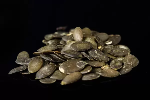 Dried saulty Pumpkin Seeds above black background (Flip 2019)