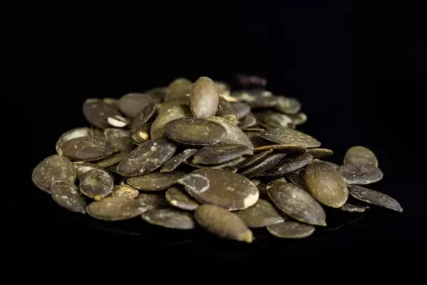 Dried saulty Pumpkin Seeds above black background