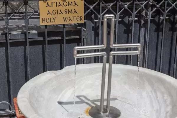 Drinking fountain with holy water in the shape of a cross