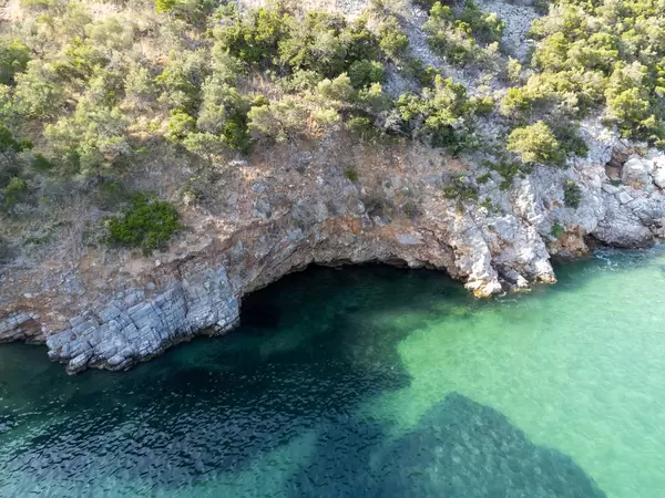 Drohnenaufnahme der Felsküste mit smaragdgrünem Wasser beim Strand Limnonari, Skopelos