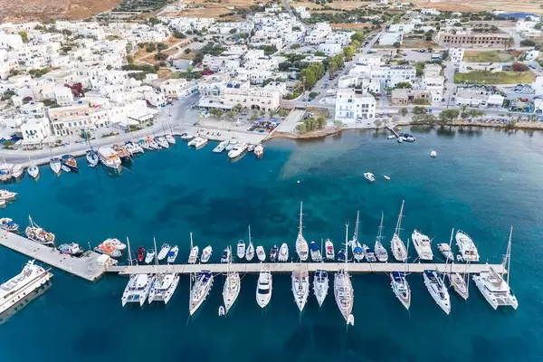 Drohnenaufnahme der Hafenstadt Adamantas. Pier mit Segelbooten und Jachten und das blaue Meer