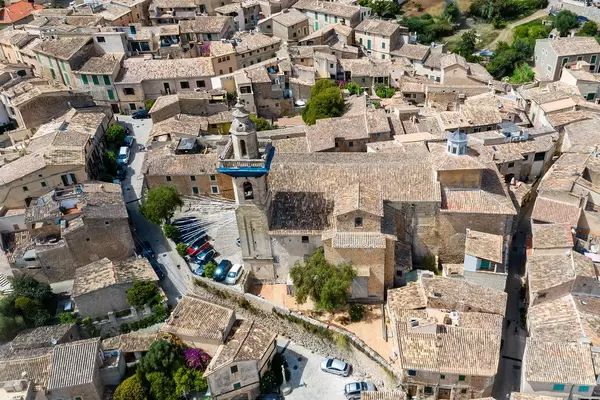 Drohnenaufnahme: Die Kirche St. Bartholomäus und die gut erhaltene Altstadt von Valldemossa, Mallorca