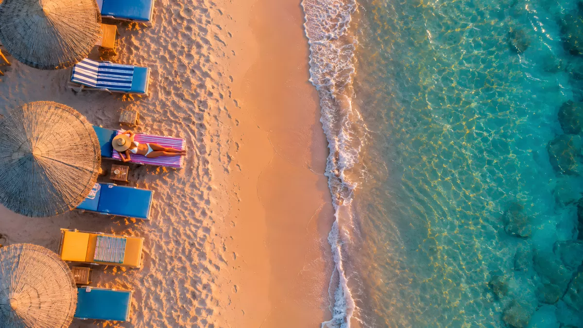 Drohnenaufnahme eines Sandstrands mit türkisem Meer