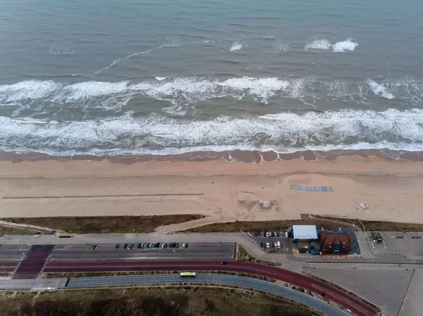 Drohnenaufnahme Strand in Bloemendaal aan Zee in den Niederlanden mit Parkplätzen und Küstenstraße