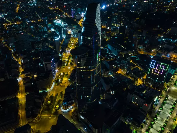 Drohnenaufnahme vom Bitexco Financial Tower mit Helikopter Landefläche neben der Nguyen Hue Fußgängerzone bei Nacht in Ho Chi Minh Stadt, Vietnam