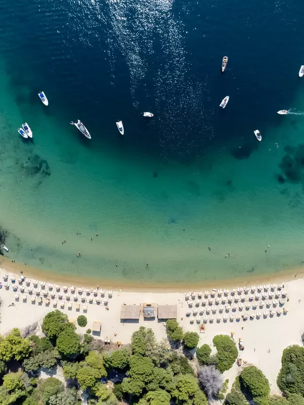 Drohnenaufnahme vom Strand mit türkisblauem Wasser auf der Insel Tsoungria bei Skiathos