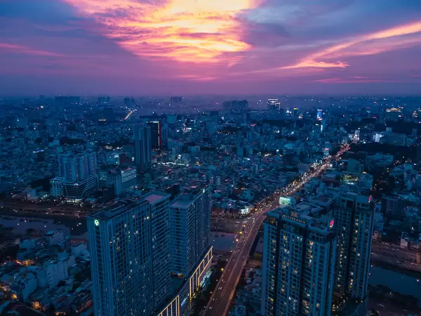 Drohnenaufnahme von Apartmentgebäuden in Distrikt 4 am Saigon Fluss mit Sicht auf das Stadtzentrum bei Sonnenuntergang in Ho Chi Minh Stadt, Vietnam