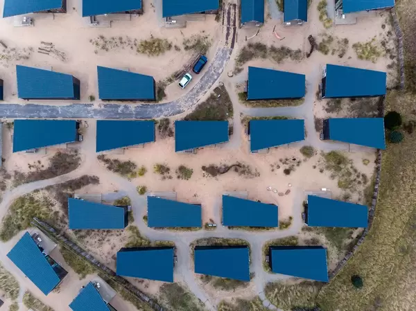 Drohnenaufnahme von blauen, asymmetrischen Dächern des Ferienparks in Bloemendaal, Niederlande