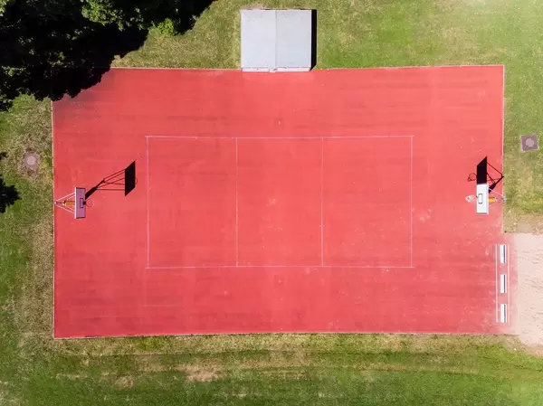 Drohnenaufnahme von rotem Basketballfeld ohne Sportler nahe dem Bayrischen Landtag in München