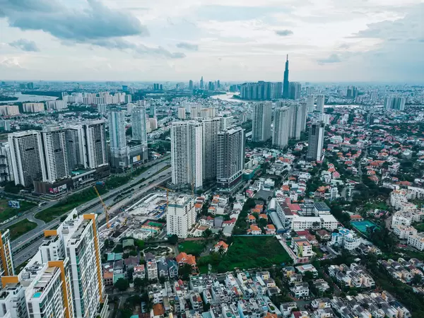 Drohnenbild der Ho Chi Minh Stadt Skyline mit vielen Apartmentgebäuden, Landmark 81, Saigon River und Bitexco Financial Tower in Vietnam