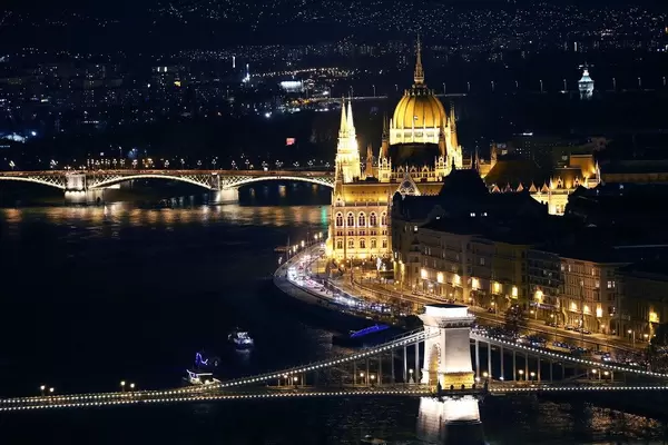 Drohnenbild und Nachtansicht von Budapest und dem beleuchteten Donauufer mit Brücke