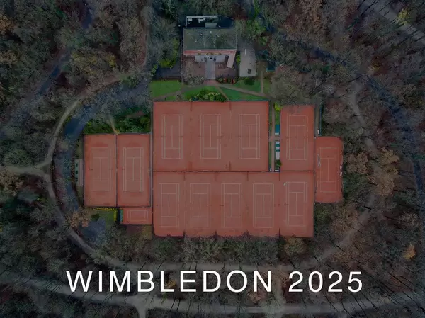 Drohnenbild zeigt Tennisplätze aus der Luft, umgeben von Wald und der Aufschrift Wimbledon 2025