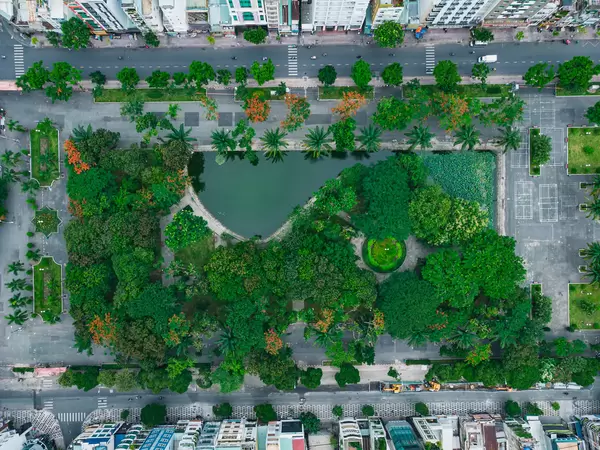 Drohnenfoto vom geschlossenen 23/9 Park mit vielen Bäumen und einem kleinen See im Stadtzentrum von Ho Chi Minh City, Vietnam