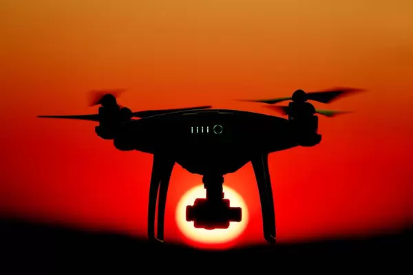 Drone facing sun at sunset, orange sky