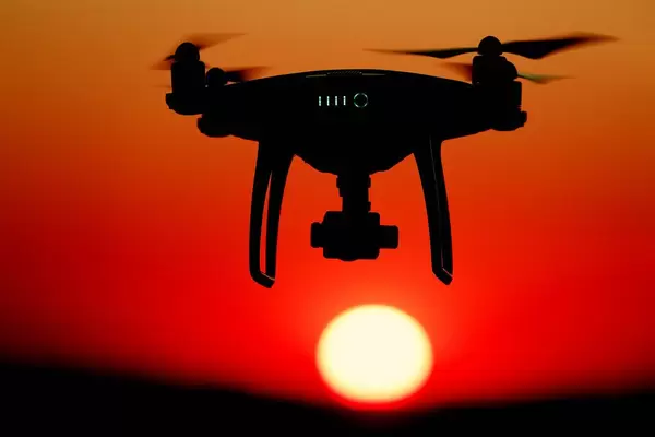 Drone flying in the sky at sunset