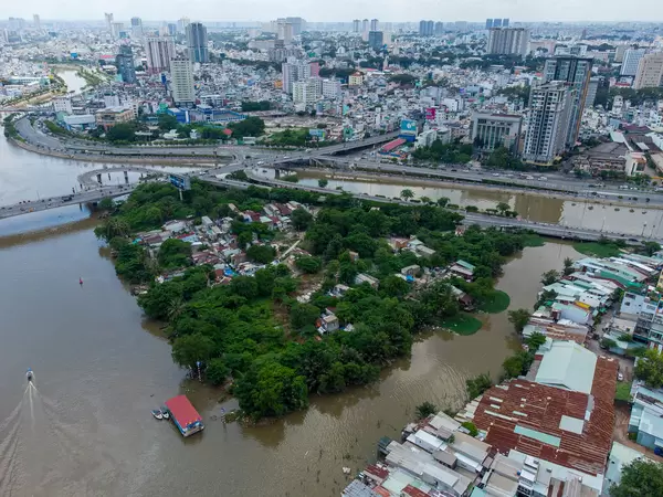 Drone Photo of a Bridge connecting a small Island with other Districts, Boats on Saigon River and many Buildings in Ho Chi Minh City, Vietnam
