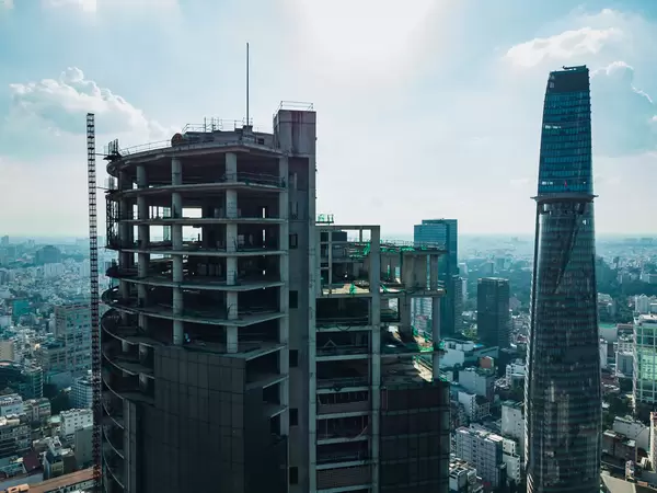 Drone Photo of abandoned Saigon One Tower Construction with Bitexco Financial Tower in the Background in Ho Chi Minh City, Vietnam