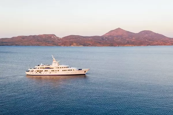 Drone photo of Blohm + Voss superyacht Astarte II at sunset at sea in Adamantas, Milos, Cyclades