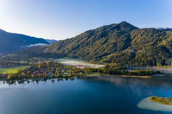 Drone photo of Lake Tegernsee with crystal clear blue water and the surrounding alpine mountains
