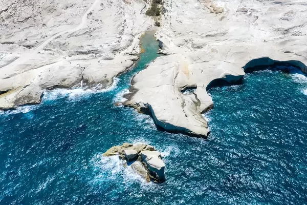 Drone photo of Sarakiniko on the Greek island of Milos with white cliffs, small bays and rough sea