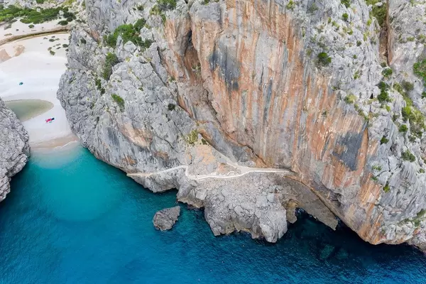 Drone photo: path crossing the steep rock face at the entrance of the canyon. Cala de Sa Calobra, Majorca