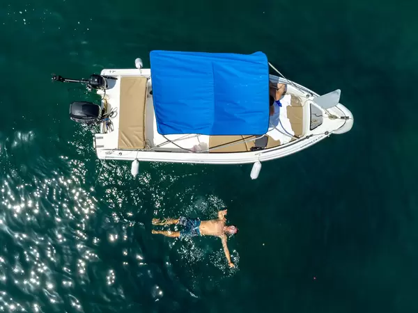 Drone photography on holiday in Greece: swimming next to the boat near Agios Dimitrios beach, Alonissos