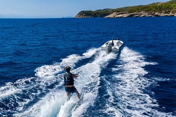 Drone picture of a water skiing at the rocky bay near Agii Anargir of the Greek holiday island Spetses