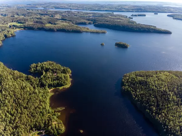 Drone picture shows lake district in Finland, with green forest areas and untouched nature around Padasjoki