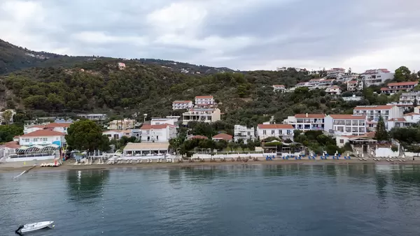 Drone shot of the hilly coast of Greek island Skiathos with houses directly on the beach: Paralia Megali Ammos